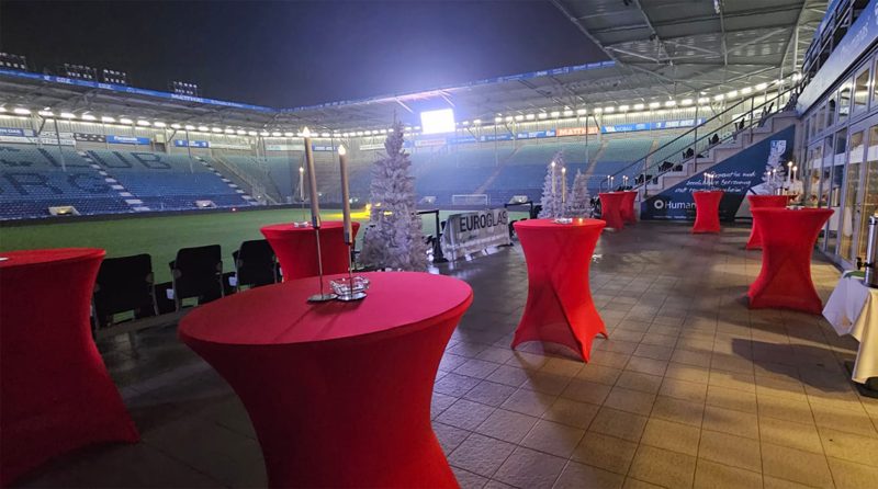 Festlich dekorierte Stehtische im Stadion bei Nacht